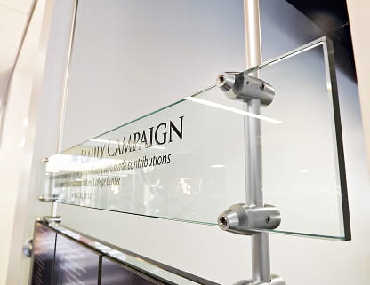 Architectural glass panel mounted securely via vertical steel support rods